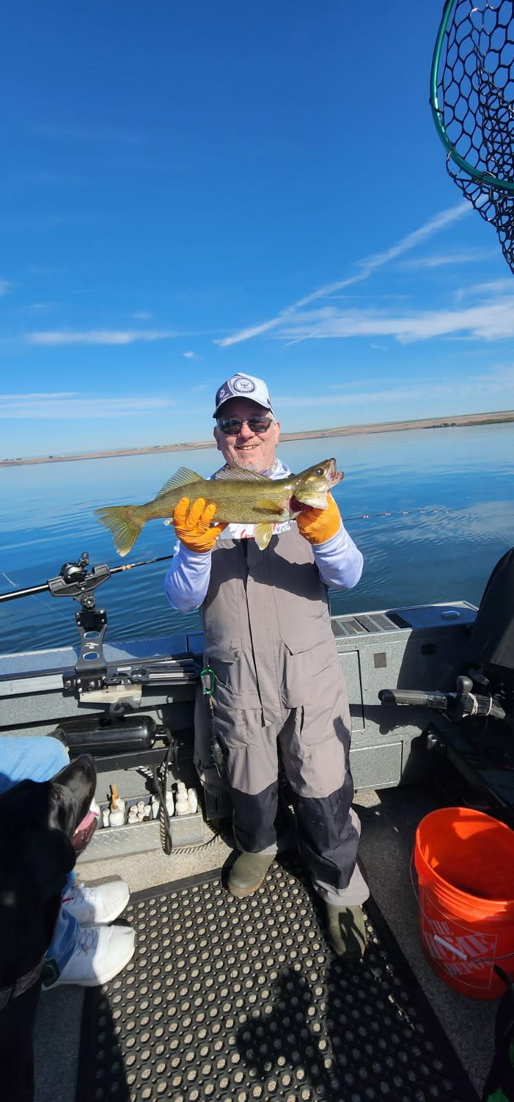 Veteran angler holding a trophy walleye on Tony's boat, bluebird Eastern Oregon Columbia River day, John Day Pool.