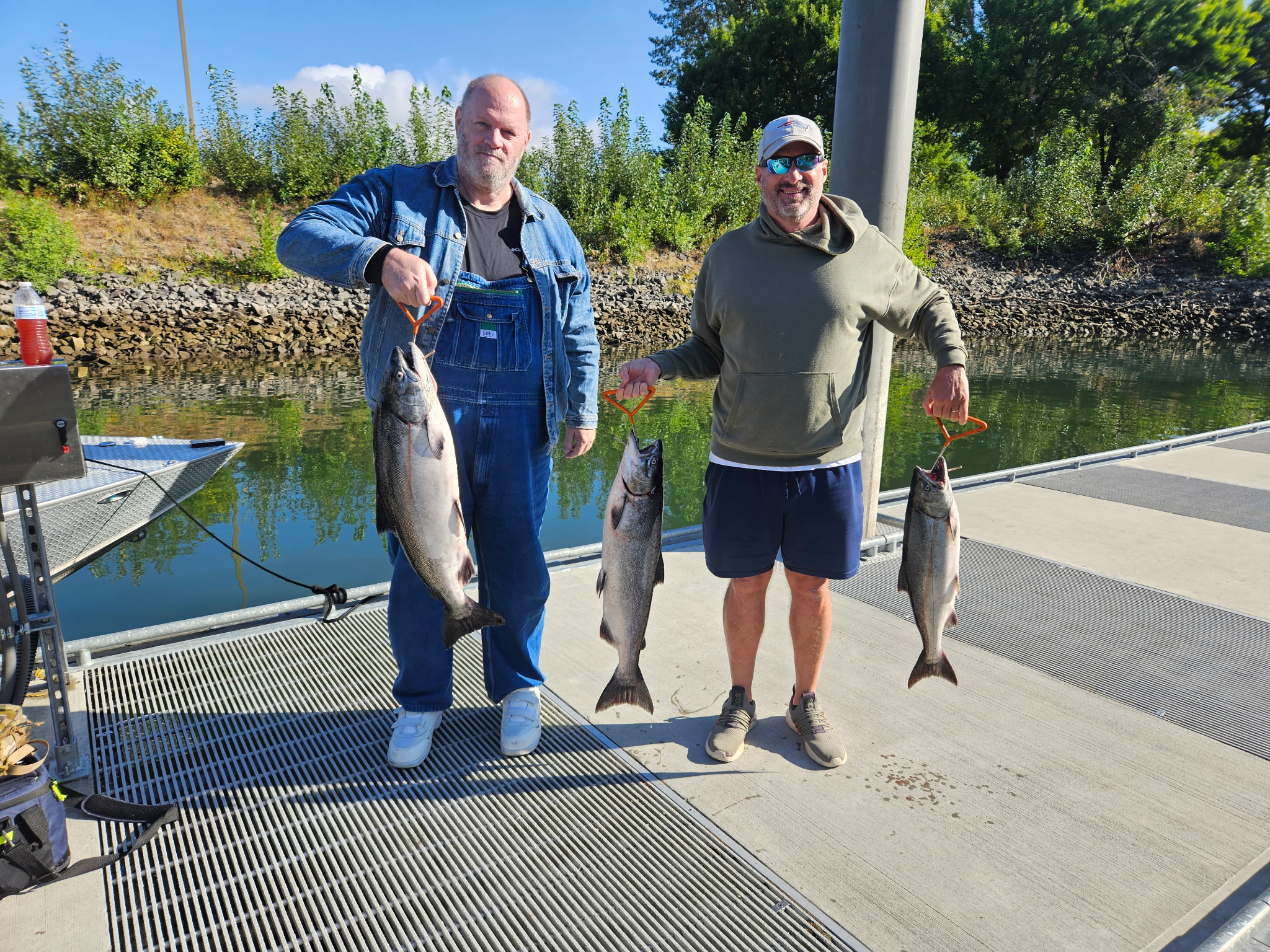 Two anglers holding a four-fish Chinook haul at the boat ramp after a guided trip with Tony O Guided Adventure.
