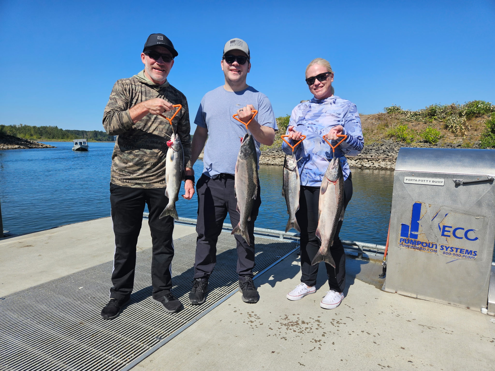 Three anglers each holding a Chinook salmon at the boat ramp on a sunny day, guided Columbia River trip with Tony O Guided Adventure.
